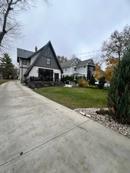Modern home with professionally manicured lawn and rock edging landscaping